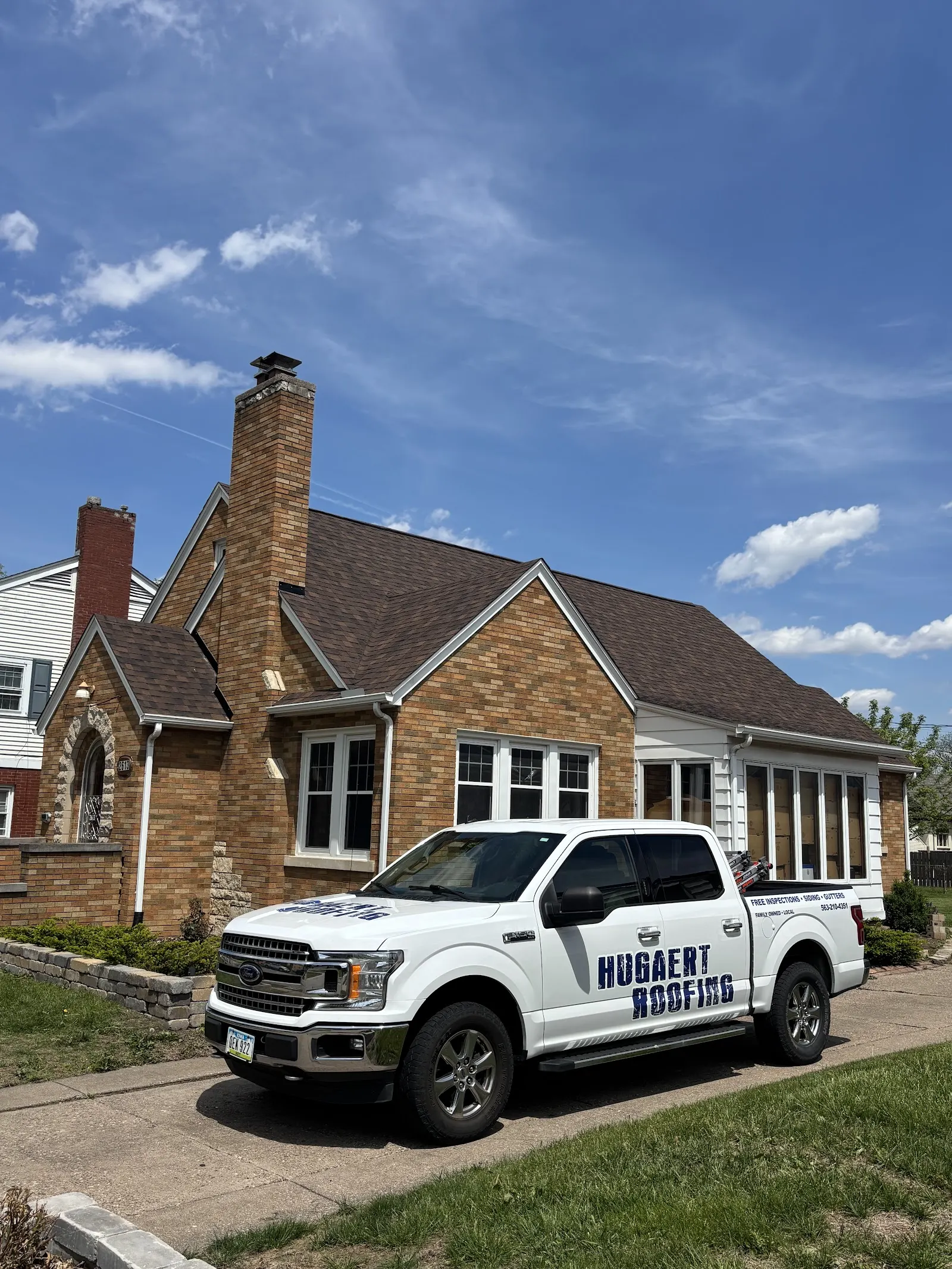 Hugaert Roofing truck at a brick home